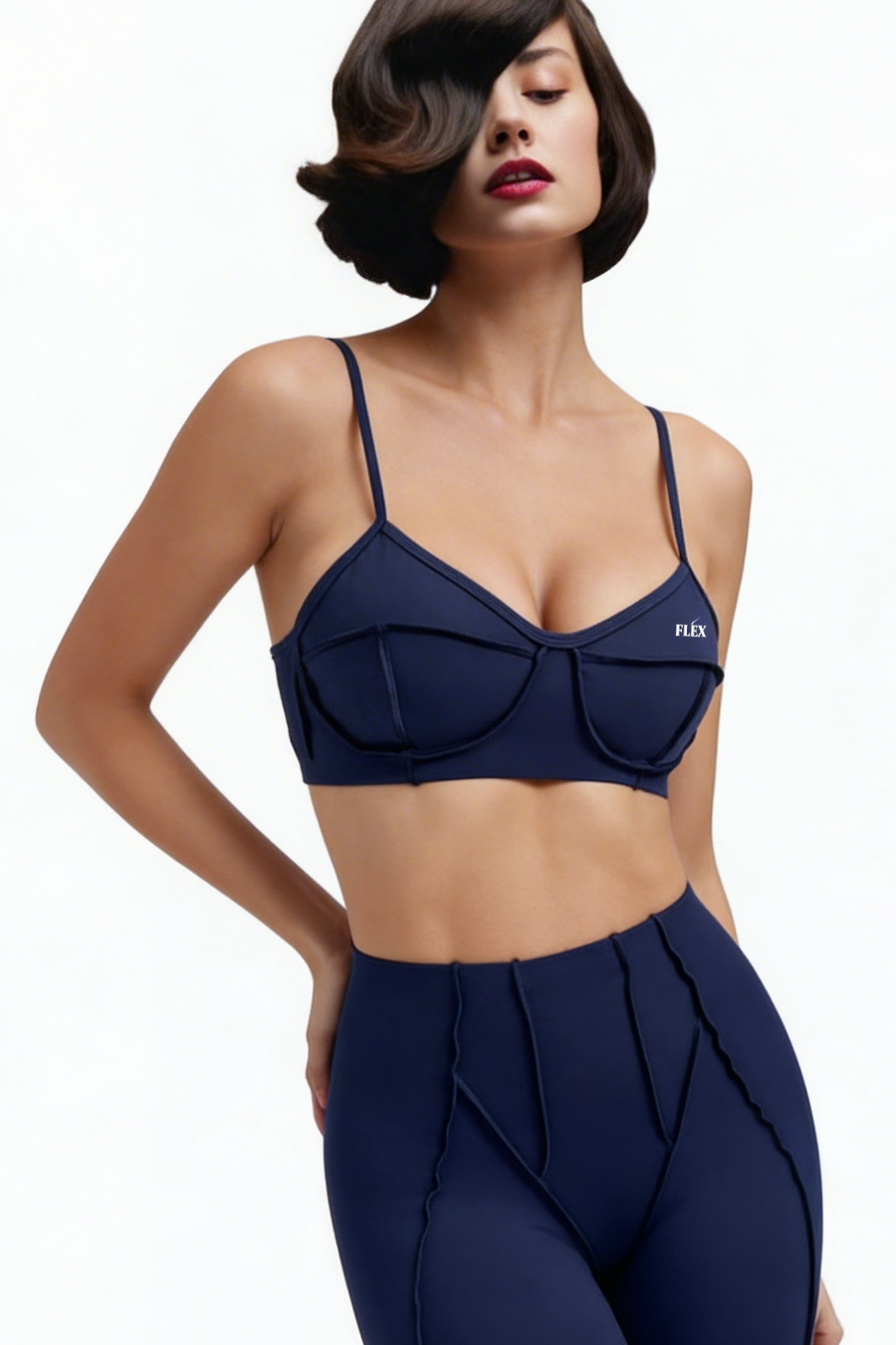 Woman wearing a navy blue sports bra and leggings with a visible brand logo on a white background