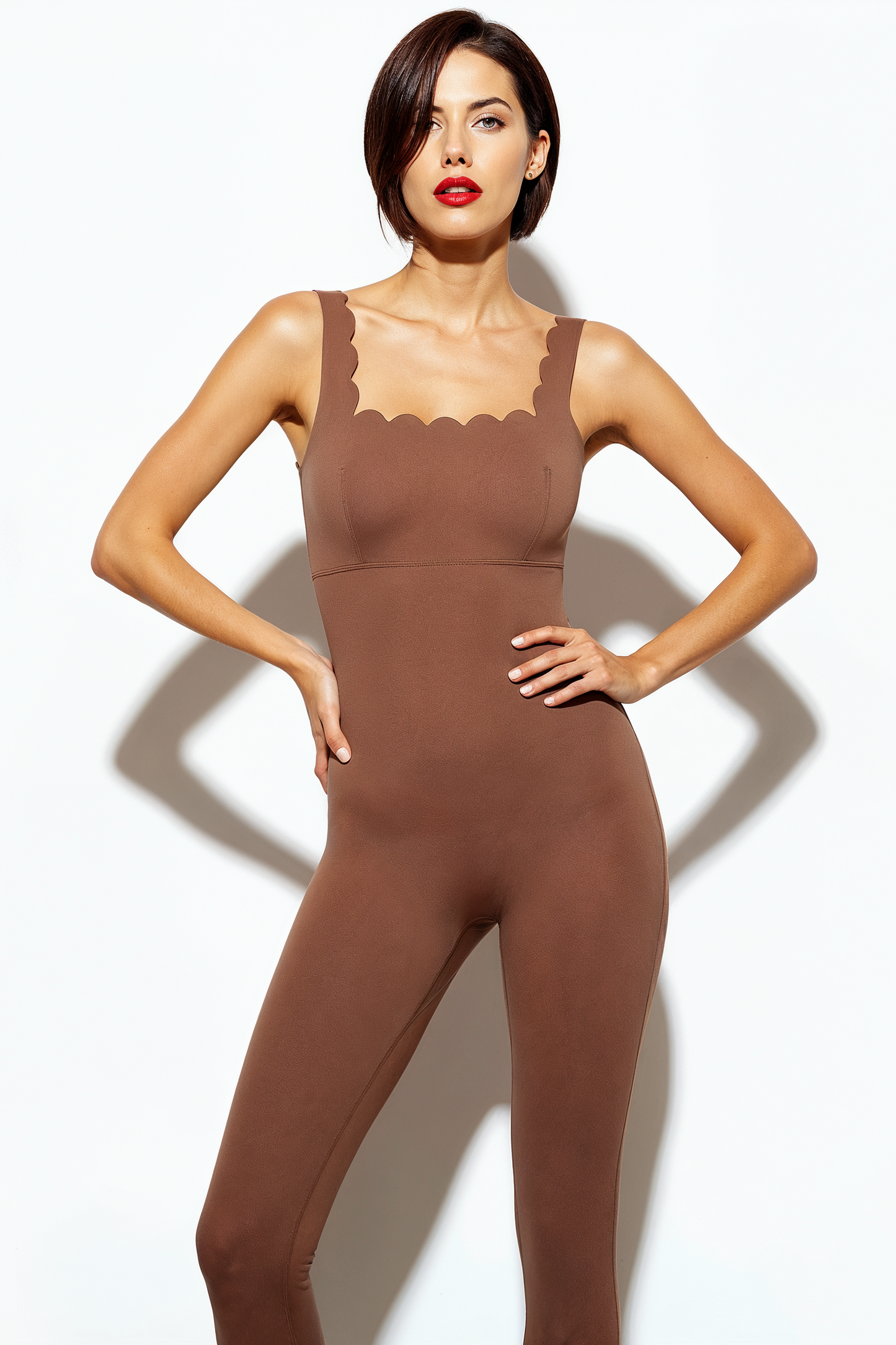Woman wearing a brown jumpsuit against a white background