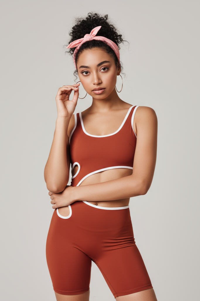 Woman wearing a red sports bra and shorts set on a plain background