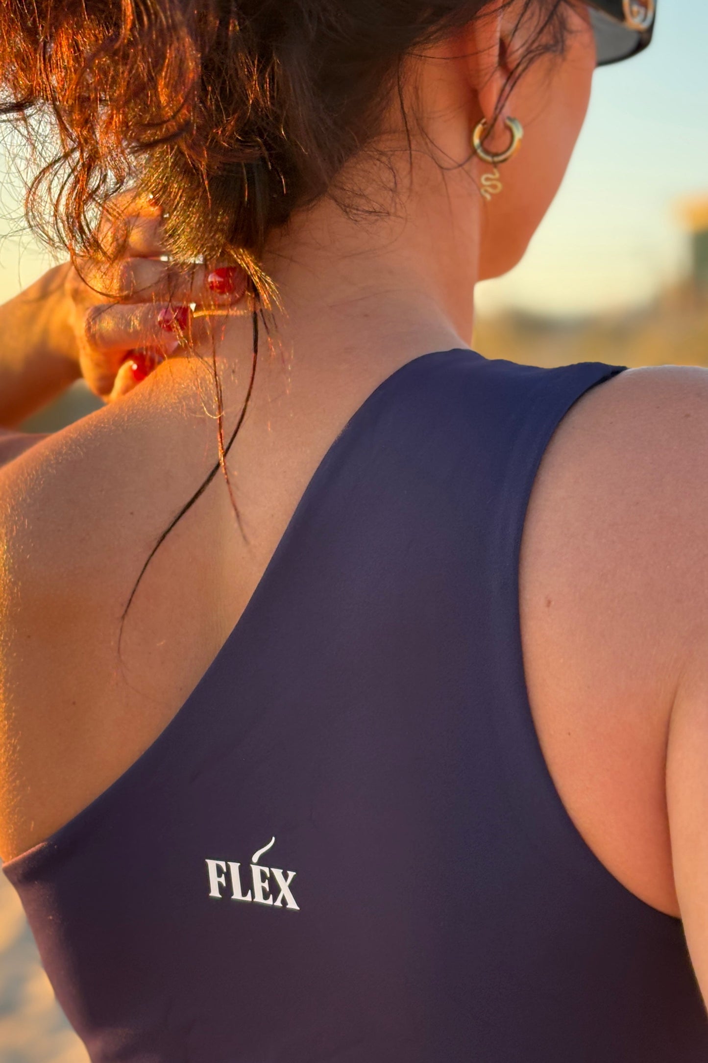 High-waisted navy jumpsuit with cut-out sides – trendy women’s summer fashion outfit.