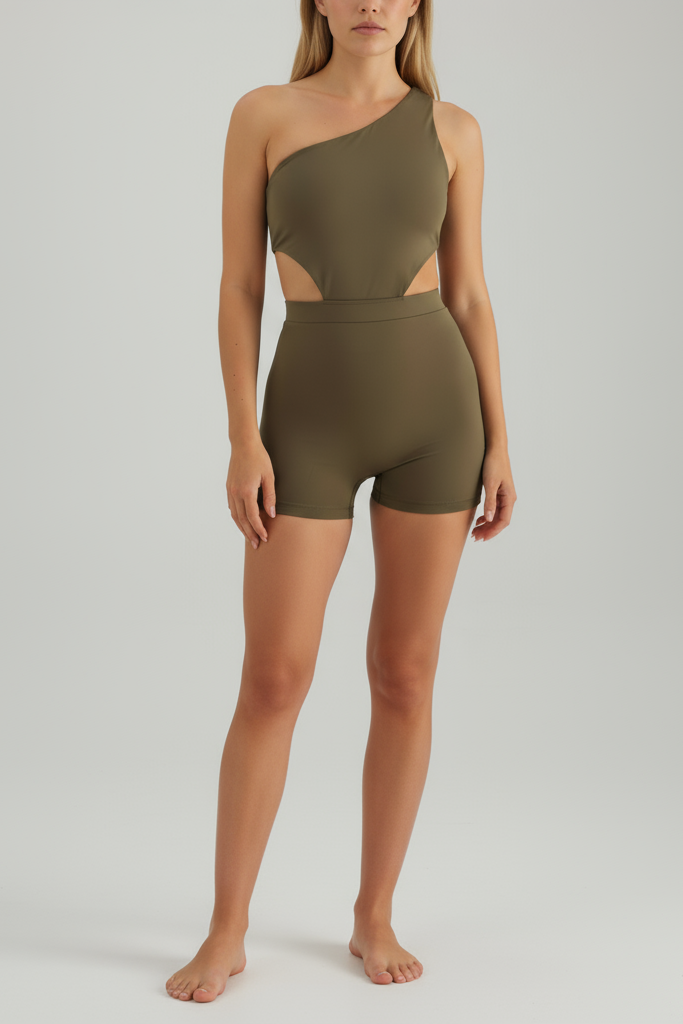 Woman wearing a green one-shoulder jumpsuit on a plain background