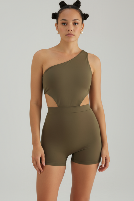 Woman wearing a green one-shoulder jumpsuit on a gray background