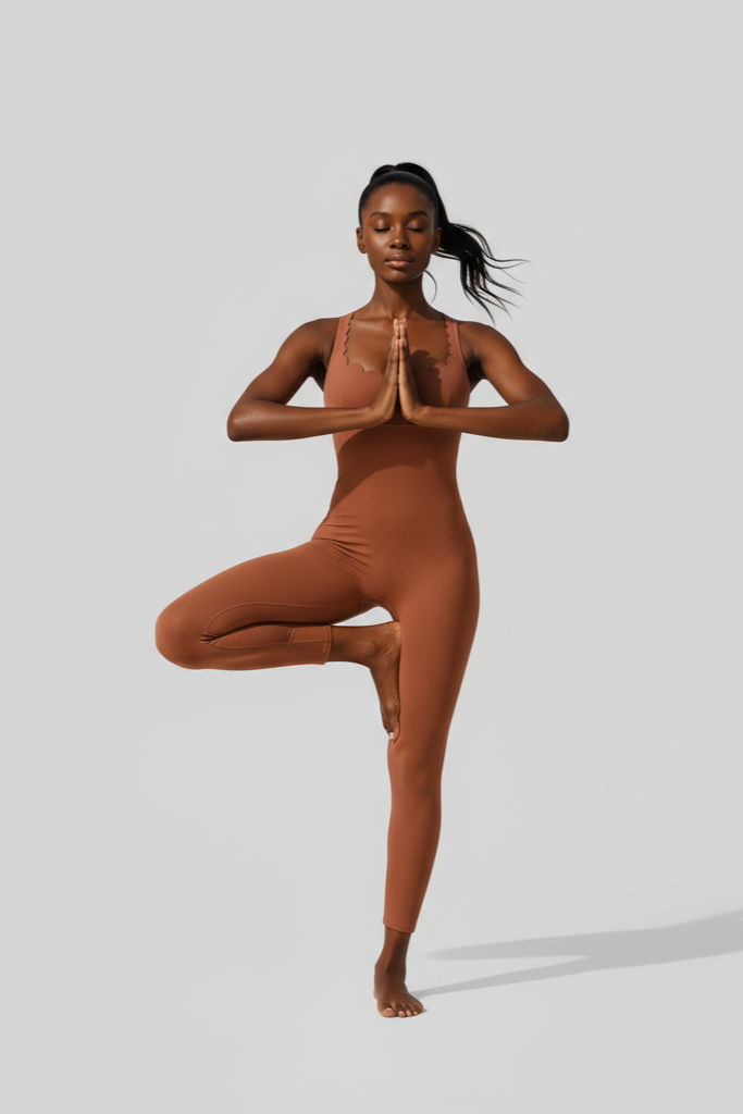 Person wearing a brown bodysuit performing a yoga pose on a light gray background